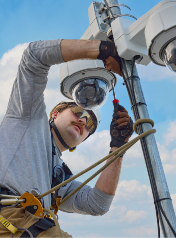 An engineer works on surveillance equipment, high atop California