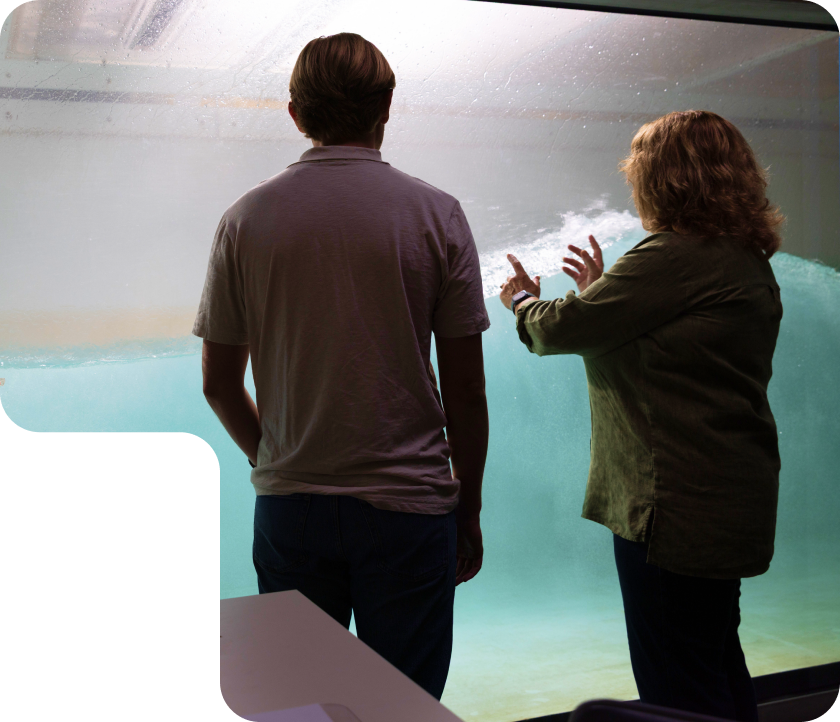 Two people reviewing man-made, in-lab wave machine